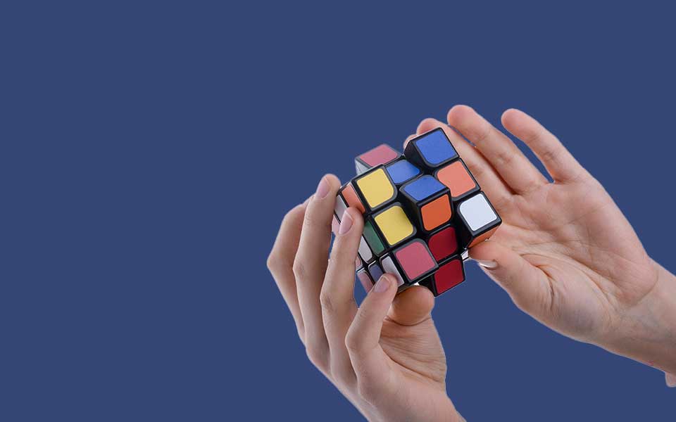 Ett par händer som löser en Rubiks Kub